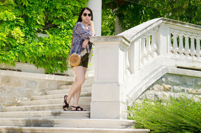 Portrait of young woman standing on staircase