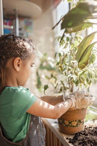 Side view of boy looking at plants