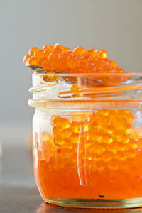 Close-up of orange juice in glass jar on table