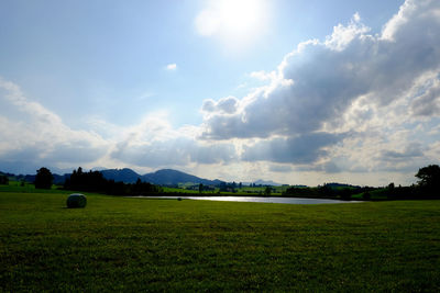 Scenic view of field against cloudy sky