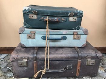 Close-up of old suitcases against wall