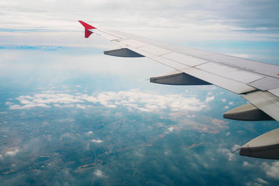 Cropped image of airplane in cloudy sky