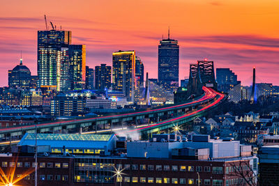 Illuminated modern buildings against sky at dusk