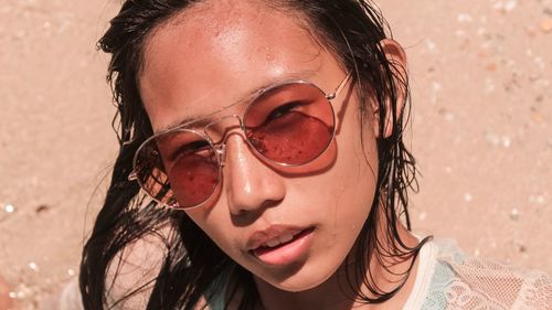 Close-up portrait of young woman wearing sunglasses