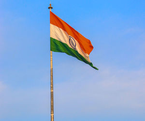 Low angle view of flag against blue sky