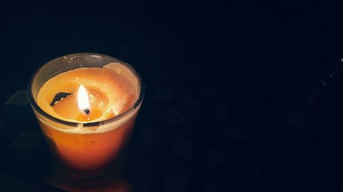 High angle view of lit candle in darkroom