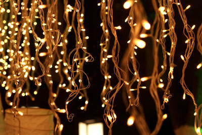 Low angle view of illuminated lights hanging at night