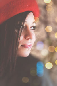 Close-up of beautiful woman wearing red headwear at night