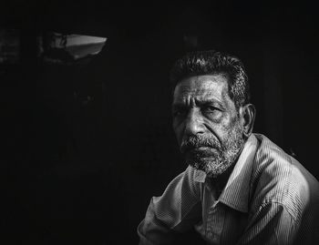 Portrait of man against black background