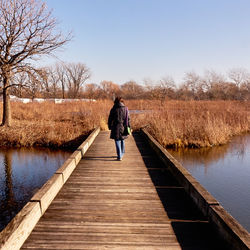 Rear view of woman standing on jetty