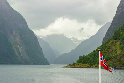 Flag of norway waving in wind on a ferry. fjord cruise, travel around scandinavia.