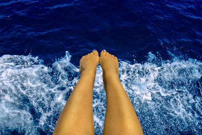 Low section of woman legs over sea