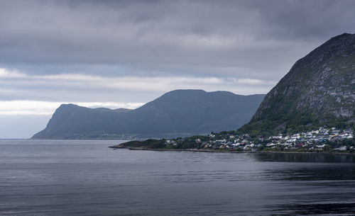 Scenic view of sea and mountains against cloudy sky