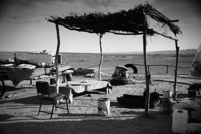 Chairs and tables on beach against sky