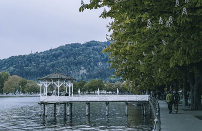 Gazebo by lake against sky