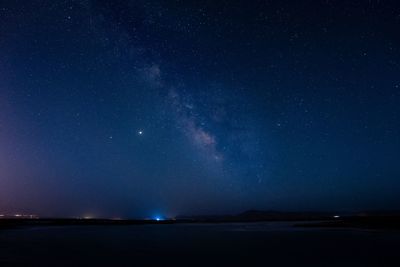 Scenic view of sea against star field at night