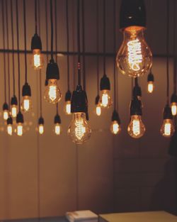 Illuminated light bulbs hanging in darkroom