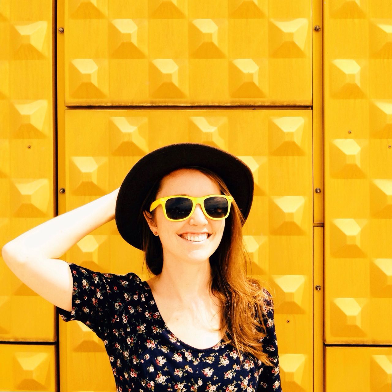 looking at camera, portrait, young adult, indoors, front view, person, lifestyles, headshot, young women, leisure activity, sunglasses, smiling, close-up, head and shoulders, casual clothing, wall - building feature, confidence