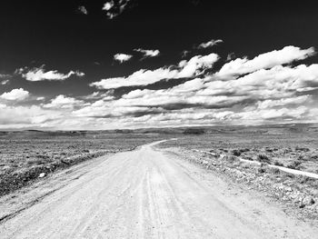 Tire tracks on road against sky