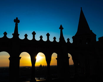 Low angle view of silhouette building against sky during sunset