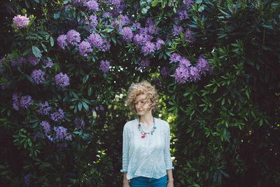 Woman standing against purple flowering plants