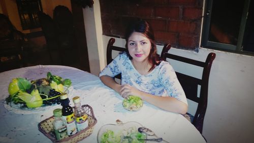 Portrait of young woman eating food at home