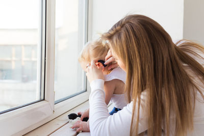 Rear view of girl sitting at home