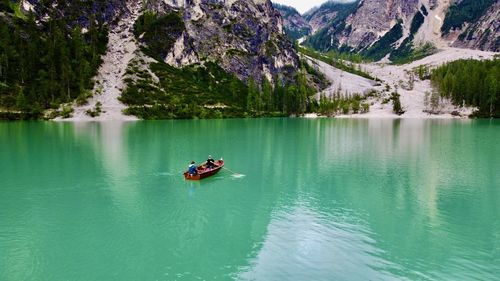 People in boat on lake against mountains