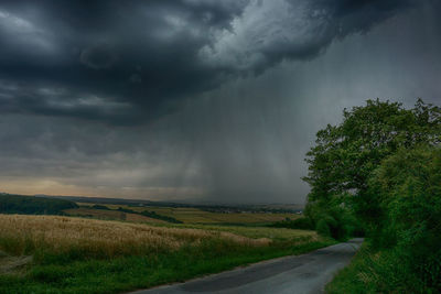 Scenic view of rural landscape against dramatic sky