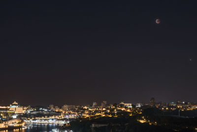 High angle view of illuminated buildings against sky at night