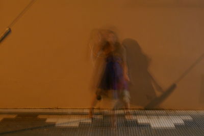 Blurred motion of people walking on wall