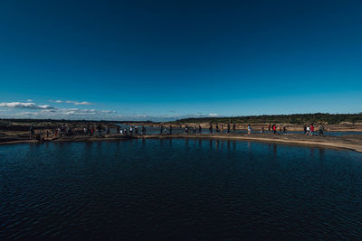 People on beach against blue sky