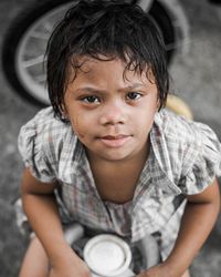 Portrait of cute girl sitting outdoors