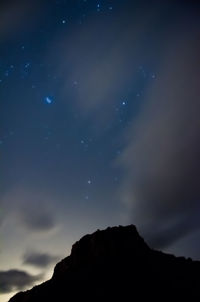 Low angle view of silhouette mountain against sky at night