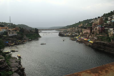 River amidst buildings in town against sky