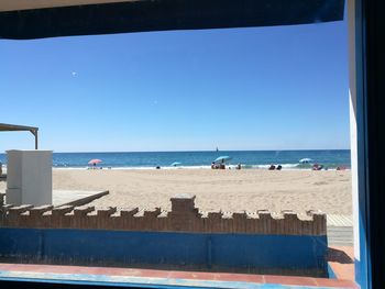 Scenic view of beach against clear blue sky