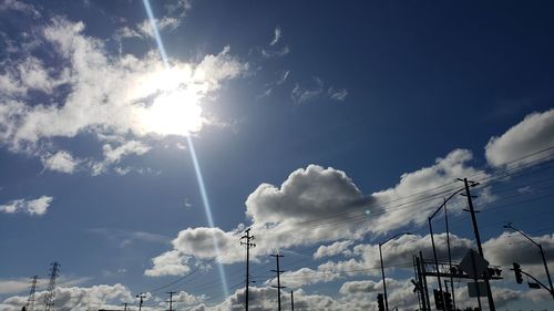 Low angle view of cables against sky on sunny day