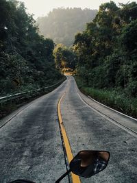 Empty road along trees