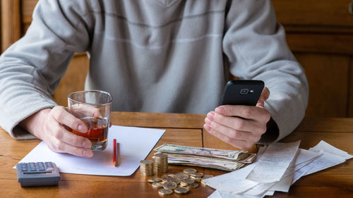 Midsection of man using laptop on table