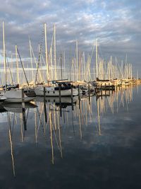 Sailboats moored in lake against sky
