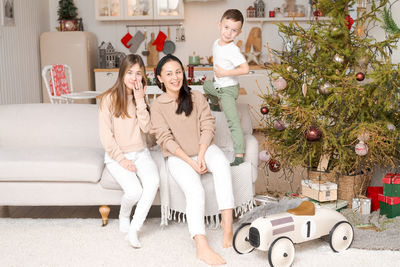 Family spends time together during christmas holidays in decorated house.