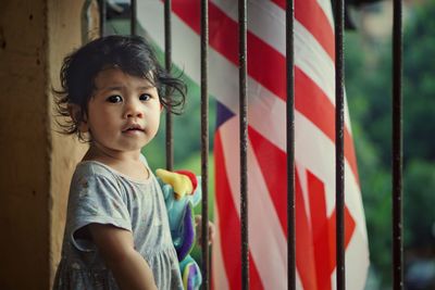 Portrait of girl standing by railing