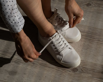 Low section of man and woman standing on wooden floor