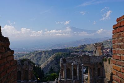 Scenic view of mt etna against sky seen from old ruins in city