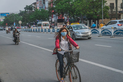 Woman riding bicycle on city street