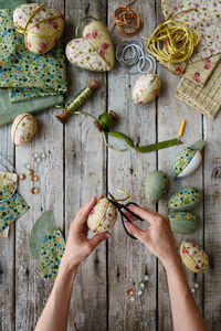 Top view of hands holding nest with easter eggs in kimekomi ornaments style. handmade easter decor