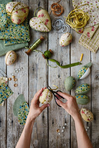 Cropped hands of woman holding christmas decorations on table