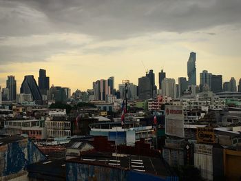 Modern buildings in city against sky during sunset