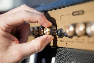 Close up of a hand controlling the volume of an amplifier