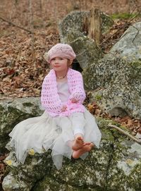 Cute girl sitting on rock